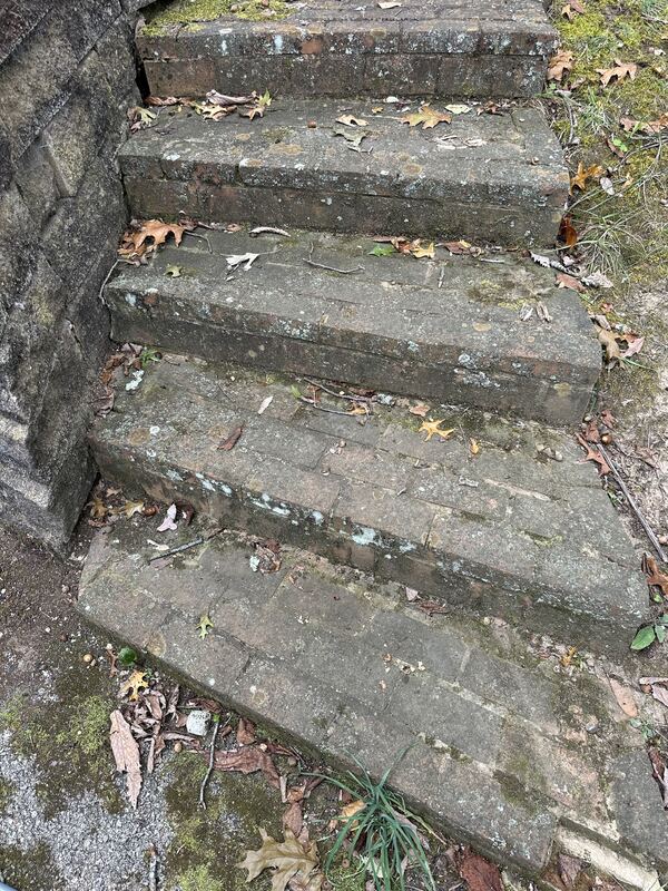 Mossy, stained brick steps before pressure washing